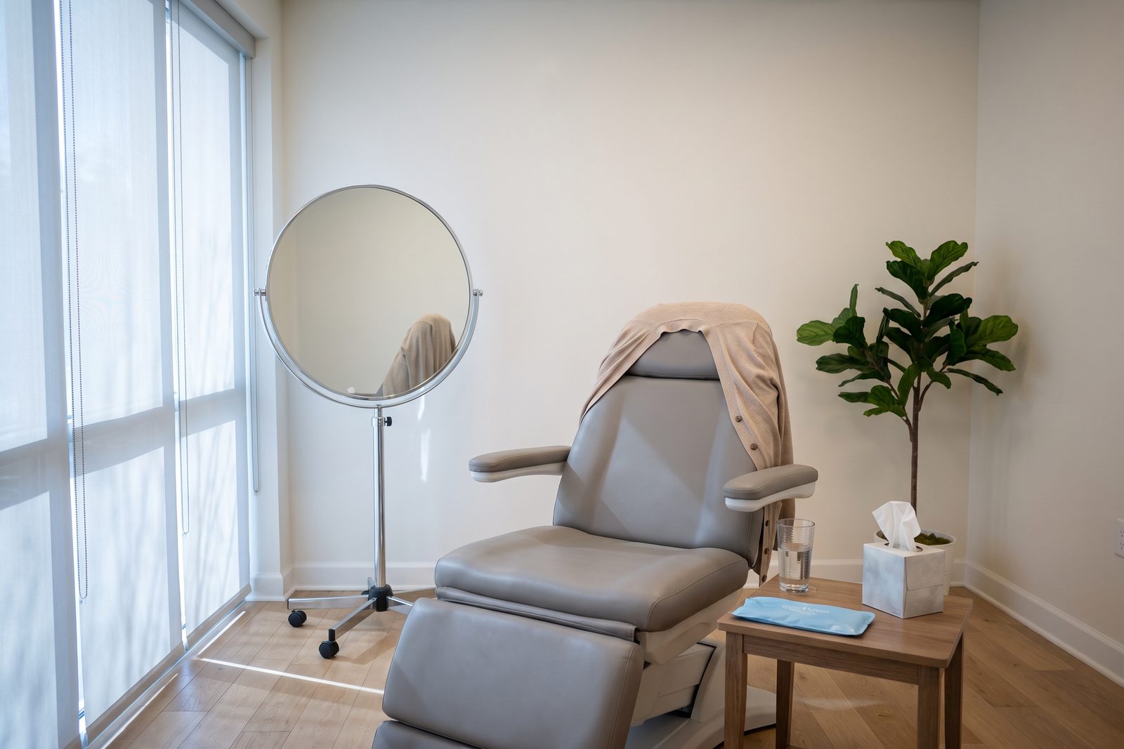 AI-generated illustration of a quiet consultation room with a padded chair, a standing round mirror and soft window light